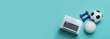 Mavi halterler, top ve gri dizüstü bilgisayar mavi arka planda. Çevrimiçi çalışma kavramı