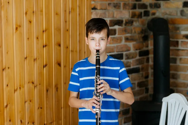 Boy with a clarinet plays music. Online music lesson concept