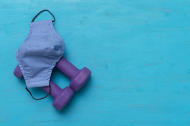 Dambıllar ve maske mavi ahşap arka planda. Güvenli spor konsepti.