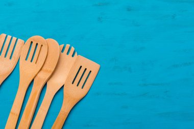 Mavi ahşap arka planda çeşitli ahşap mutfak aletlerinin üst görüntüsü. Sıfır atık