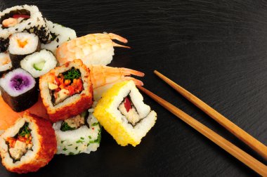 Karışık Sushi kayrak bir arka plan üzerinde rulo