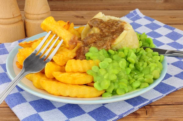 Biff och njur Pudding måltid med Chips och mosig ärter — Stockfoto