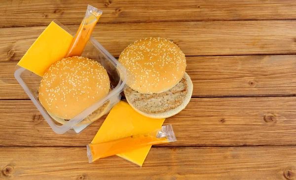 Twee Magnetronhamburgers Met Kaas Saus Een Houten Ondergrond — Stockfoto