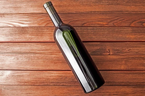 Ahşap bir masa üzerinde karanlık şarap şişe. — Stok fotoğraf