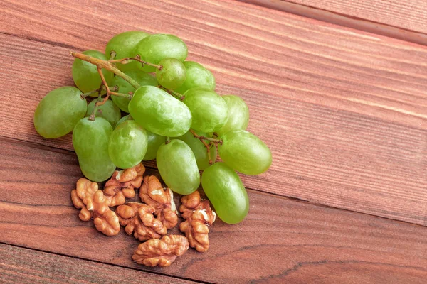 绿色的葡萄和核桃木制的桌子上. — 图库照片