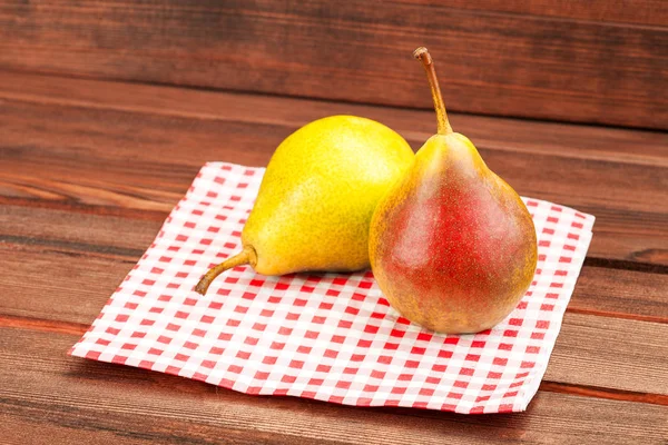 Pera en servilleta rojo-blanca en la mesa . — Foto de Stock