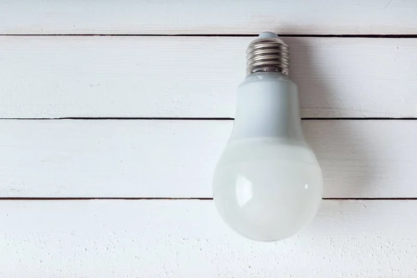 led bulb lies on woode table.