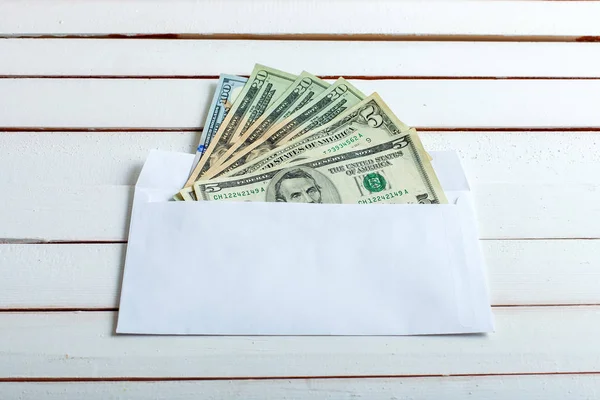 Contant geld in een envelop op witte houten tafel. — Stockfoto