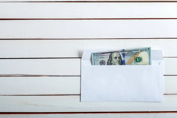 Dinheiro em um envelope na mesa de madeira branca . — Fotografia de Stock