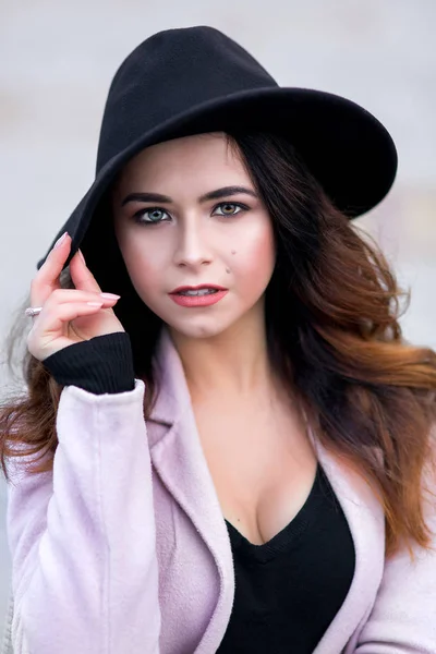 The girl in a coat with black hat on head. — Stock Photo, Image