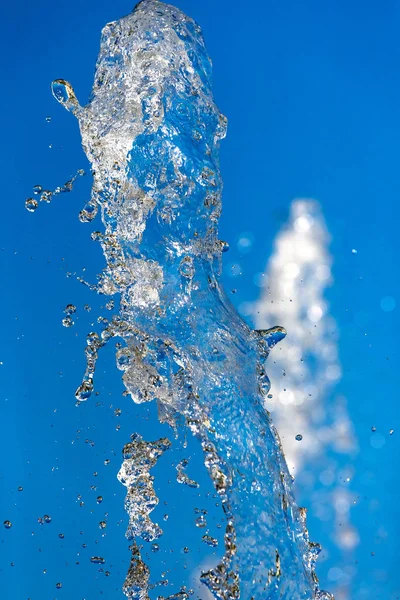 Vattenstänk på blå bakgrund. — Stockfoto