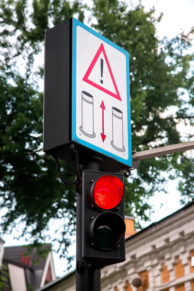 red traffic light with warning sign.
