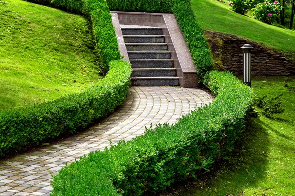 石阶上有人行横道 由矮树丛环绕 丘陵地带有绿草的瓷砖铺成 没有人 — 图库照片