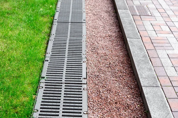 drainage system in the park, drainage grate and pebbles close up detail.