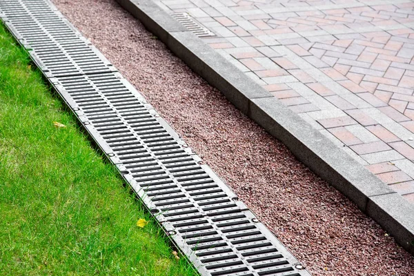 Entwässerungssystem Park Zwischen Grünem Gras Und Steinpflaster Entwässerungsrost Und Kieselsteinen — Stockfoto