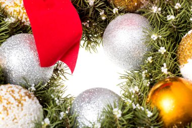 Çam iğnesi çerçevesi şeklinde bir Noel teması ve görüntünün ortasında boşluk olan bir Noel ağacı oyuncağı..