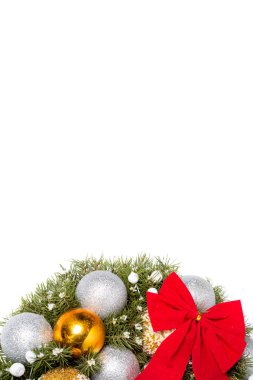 Üzerinde kırmızı yay ve noel oyuncakları olan boş bir Noel çelengi. Beyaz bir zemin üzerinde izole edilmiş boncuklardan yapılmış oyuncak toplar ve yeni yıl için metin alanı..