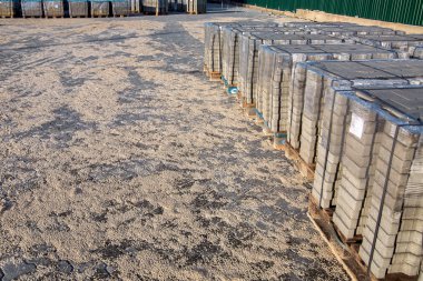 Bölgede yeni asfalt levhalar bulunan paletler gruplandırmak için kumla döşenmiş taş kiremitlerle döşenmiş..