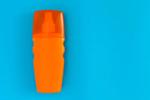 Orangefarbene Flasche Mit Sonnencreme Zum Bräunen Liegt Auf Blauem Hintergrund — Stockfoto