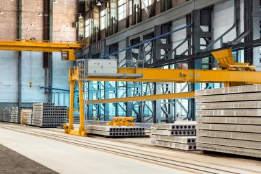 Otomatik ekipman ve teçhizatla dolu bir atölyede yığınla döşeme plakası üreten bir fabrikanın sanayi tesisleri..