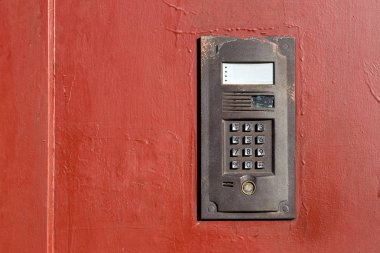 Metall eski kapısında bir dahili telefon ve kopyalama alanı ile kapatmak için bir tuş takımı.