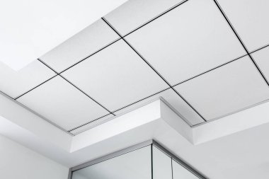 Üç boyutlu çıkıntıları olan çok katlı tavan ve askıya alınmış tavan beyaz rengi, geometrik ayrıntıları kapat.