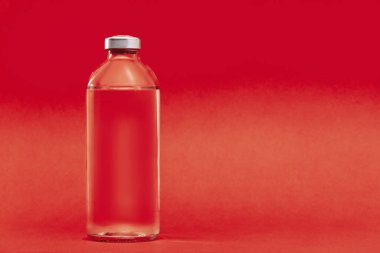 Hastaların aşılanması için sıvı içeren cam şişe kırmızı zemin üzerinde fotokopi alanı olan sağlık tedavisi için..