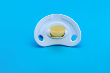 Yumuşak silikondan yapılmış mavi bir emzik. Mavi arka plan görünümünde ve kopyalama alanı ile izole edilmiş..