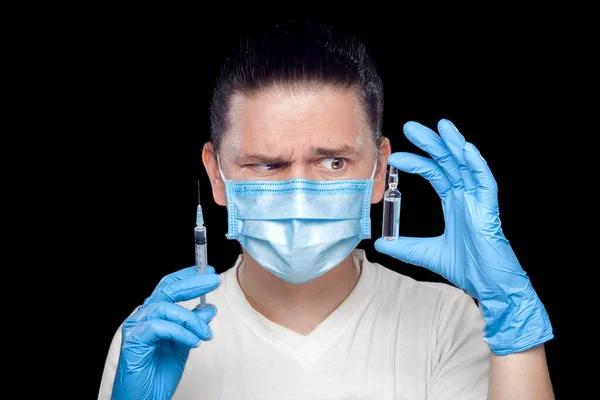 Γιατρός Κοιτάζει Ύποπτα Στη Δυσπιστία Μια Ιατρική Μάσκα Και Αποστειρωμένα — Φωτογραφία Αρχείου