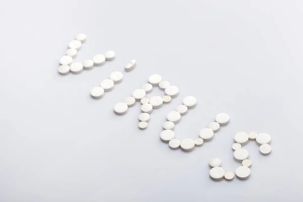 Virusinscriptie Gemaakt Van Ronde Witte Pillen Een Witte Achtergrond Medisch — Stockfoto