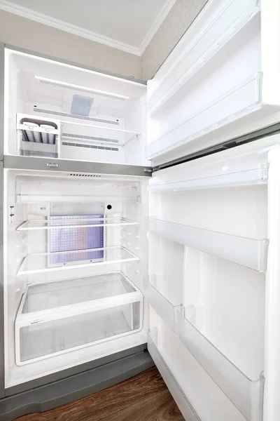 empty refrigerator during quarantine; shelves and doors of the refrigerator and freezer are free of food inside view.