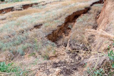 Çevresel bir çayırda heyelan. Büyük toprak tabakalarının altında tehlikeli bir çatlak. Kimse yaklaşamaz..