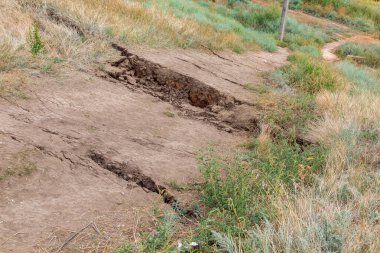 Topraktaki çatlaklar toprak kaymasından kaynaklanıyor. Tehlikeli bir doğal katoclyzmanın yakın çekimi..
