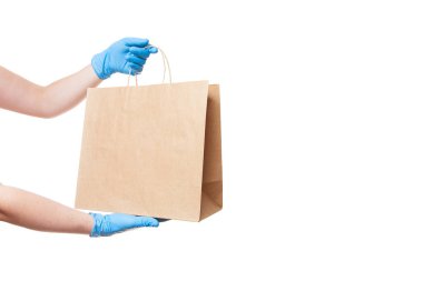 Coronavirus covid-19 salgınının karantinası sırasında güvenli bir şekilde yiyecek teslimatı için bir kuryenin steril eldivenleri beyaz arka planda izole edilmiş fotokopi alanı ile birlikte..