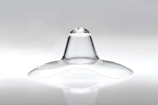 Göğüs ucu kalkanına dokunarak emzirme güçlüğü, düz ya da ters meme uçları, silikon göğüs ucu koruyucuları, gri arka planda kimse yok..