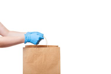 Kahverengi el işi kağıt eko dostane paket steril eldivenli teslimatçının elini tut beyaz arka planda fotokopi alanı ile izole edilmiş, virüs karantina sırasında güvenli teslimat, evde kal.
