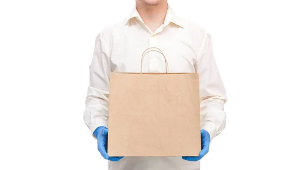 配達人の手の滅菌手袋の宅配便の安全な配達食品のためのUnlabelクラフト環境に優しいパッケージのコロナウイルスの隔離中にCovid 19パンデミック白の背景に隔離 — ストック写真