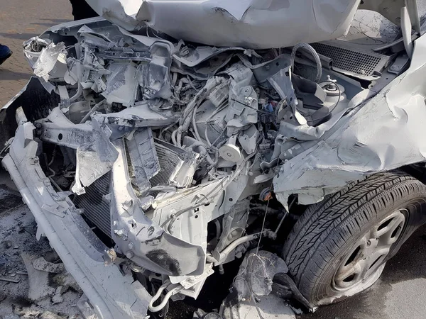 engine compartment damaged by accident and covered with a layer of white foam after extinguishing a car in a disaster, close-up of damaged parts after a front collision.