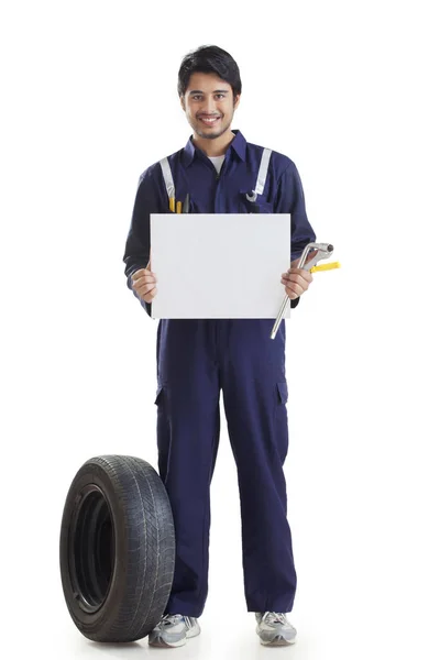 Mecânico segurando cartão em branco — Fotografia de Stock