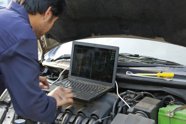 Mechanik užívající laptop na motor — Stock fotografie