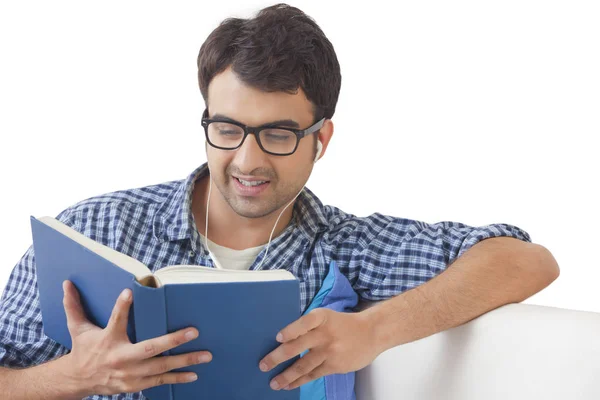 Man reading book and listening music — Stock Photo, Image