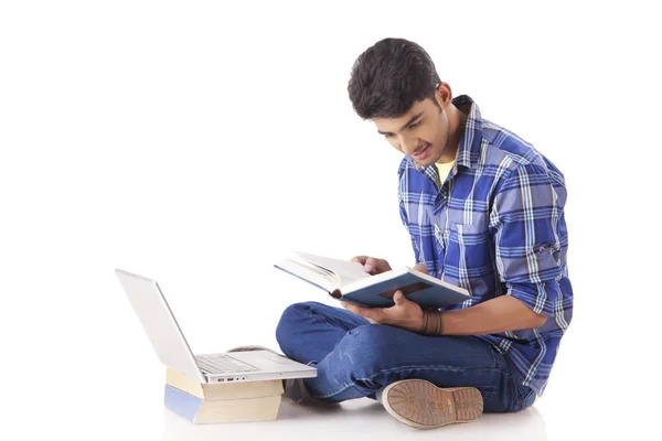Mann mit Laptop liest Buch — Stockfoto