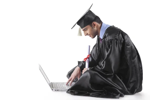 Estudiante graduado con un ordenador portátil — Foto de Stock