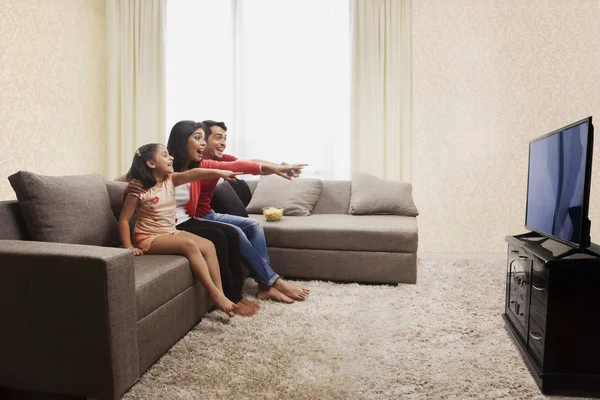Familia apuntando a la televisión — Foto de Stock