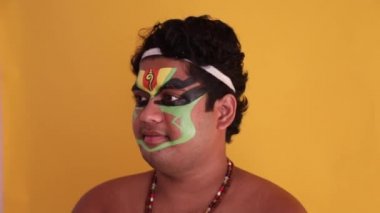 Kathakali dansçısı makyajının ilk aşamasını gösteriyor.. 