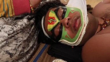 Kathakali dansçı uyurken makyaj sanatçısı yüzüne Chutty yapıştırıyor.. 