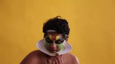 Kathakali dansçısı aynadaki chutty şeklini kontrol ediyor.. 