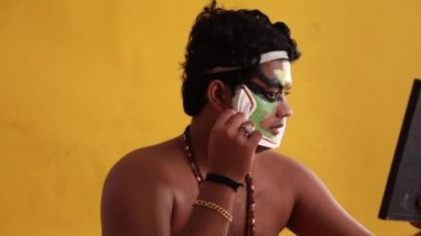 Kathakali dansçısı aynadaki chutty şeklini kontrol ediyor.. 