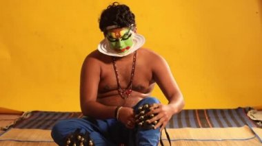 Kathakali dansçısı, gösteri için hazırlanırken ghungroo 'yu bağlıyor.. 