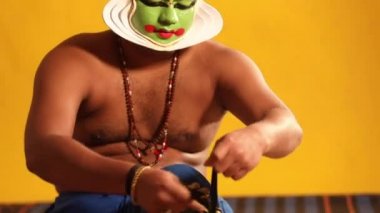 Kathakali dansçısı, gösteri için hazırlanırken ghungroo 'yu bağlıyor.. 